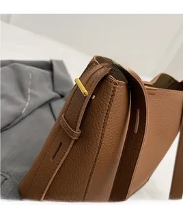Detail of brown litchi pattern leather bag showing adjustable strap and gold hardware