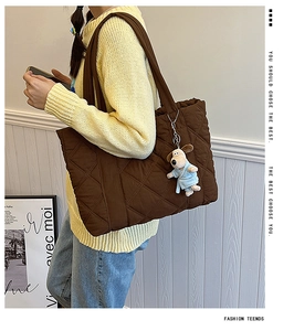 Close-up of quilted dark brown nylon tote bag with a cute puppy plush charm pendant