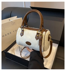 Sac Boston en fausse fourrure blanche avec anses en cuir marron dans un coffret cadeau noir