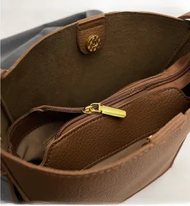 Detail of lychee pattern brown leather bag with golden zipper and magnetic closure