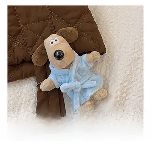 Detail of a plush dog bag charm in a blue bathrobe on a quilted nylon tote bag