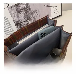 Detailed interior of a plaid tote bag showing multiple compartments and large capacity