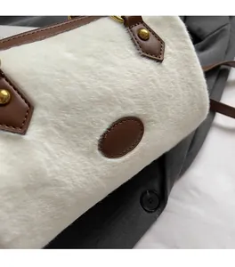 Détail de la texture en fausse fourrure blanche et finitions en cuir marron du sac