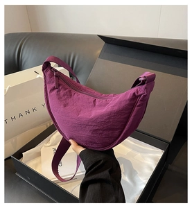 Unboxing detail of purple crescent canvas bag in premium gift box with wide strap