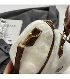 Détail de la texture en fausse fourrure blanche et sangle en cuir brun avec boucle dorée