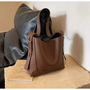 Close-up of brown lychee grain leather bucket bag with premium gold metal hardware