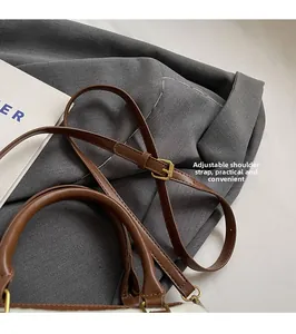 Détail du sac en fausse fourrure blanche avec bandoulière réglable en cuir marron et boucle