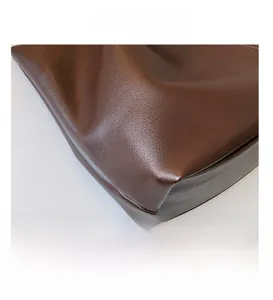 Close-up of premium brown lychee pattern leather with high-quality stitching on tote bag