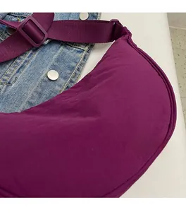 Detailed macro view of soft purple nylon fabric and adjustable strap of this crossbody bag