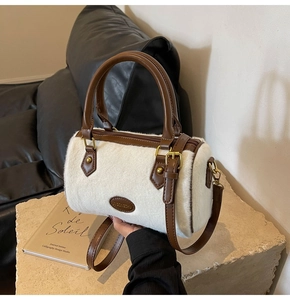 Détail du sac à main en peluche blanche avec finitions en cuir marron et boucles dorées