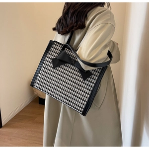 Dettaglio della borsa shopper pied-de-poule con un grande fiocco decorativo in pelle