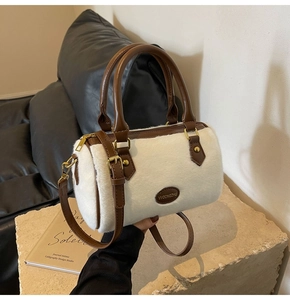 Vue détaillée du sac en fausse fourrure blanche avec lanières en cuir marron sur socle