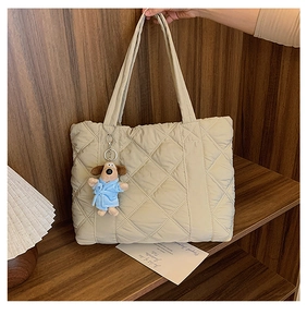 Detailed close-up of beige quilted nylon tote bag with a plush puppy keychain pendant
