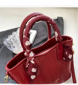 Detail of burgundy tote bag with wave texture and heart pattern scarf on handle