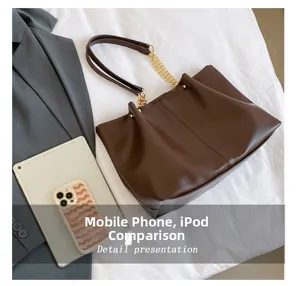 Large brown tote bag detail showing internal capacity compared with tablet and phone