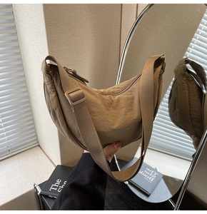 Detail of khaki crescent nylon bag showing textured fabric and wide adjustable strap