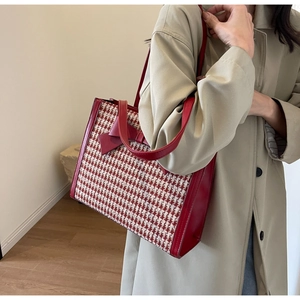 Dettaglio borsa tote a quadretti rossi con fiocco e finiture in pelle sulla modella