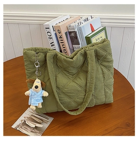 Close-up of green quilted nylon tote bag with rhombus pattern and cute plush dog charm
