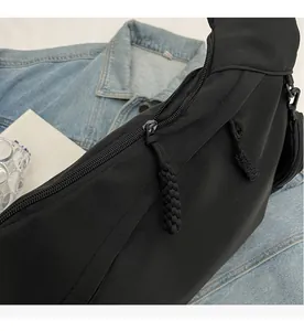 Detail of smooth double zipper closures on durable black nylon sling bag fabric