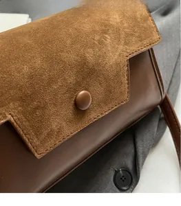 Detail shot of vintage brown crossbody bag featuring suede and smooth leather textures