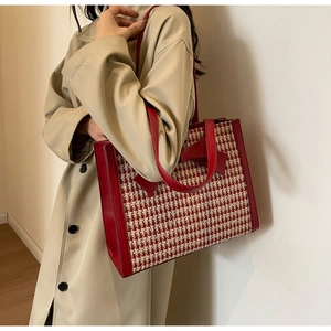 Borsa tote pied-de-poule biancorossa con dettaglio fiocco in pelle e tracolla sulla modella