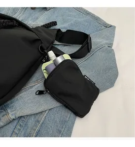 Macro detail of black nylon pouch with zip closure and hook attached to a denim jacket
