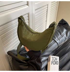 Detail of olive green nylon crescent bag showing smooth fabric texture and zipper