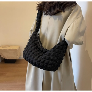Detail of black popcorn texture nylon hobo bag showing 3D pleated surface and metal zipper