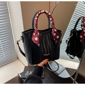 Detail of black bucket bag with wave texture and heart pattern silk scarf handle