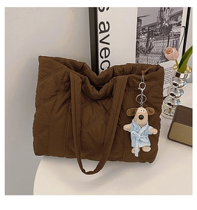 Detail of coffee nylon quilted tote bag featuring a cute plush dog pendant accessory