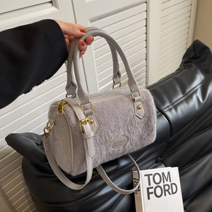 Vue détaillée du sac pelucheux gris clair avec poignées en cuir et finitions dorées
