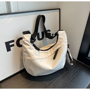 Detail view of white nylon crescent bag with wide black strap and detachable coin pouch