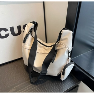 Close-up of white crescent nylon bag with adjustable black strap and mini coin purse