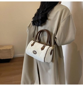 Détail du sac Boston en peluche blanche avec garniture en cuir porté par un mannequin