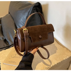 Detail of dark brown patchwork leather handbag with premium gold hardware and flap texture