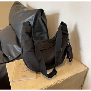 Detail view of the black nylon hobo bag with a matching small detachable coin purse charm