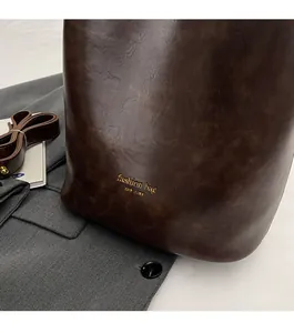 Macro shot of dark brown oil wax leather bag texture with gold fashion bag logo