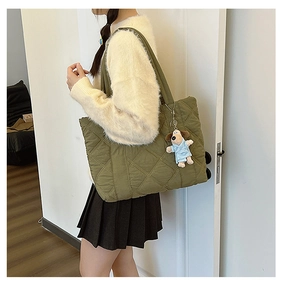 Olive green quilted nylon tote bag with cute dog pendant shown on shoulder