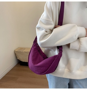 Detail of purple crescent nylon crossbody bag with adjustable wide strap and zip closure