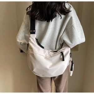 Detail of off-white nylon dumpling bag with black strap and mini round coin pouch