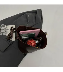 Top view of large brown leather bucket bag showing spacious interior with tablet and umbrella