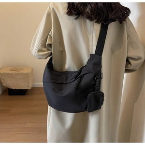 Black large nylon crossbody dumpling bag with detachable pouch shown on model