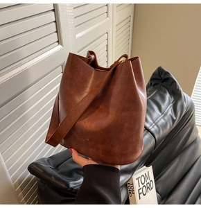 Detailed view of vintage brown leather bucket bag with gold NEW YORK lettering logo