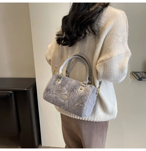 Détail d'un sac polochon en fausse fourrure grise avec finitions cuir et métal doré