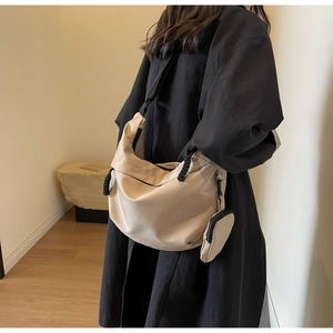 Detail of beige nylon crossbody bag with adjustable strap and small round coin purse