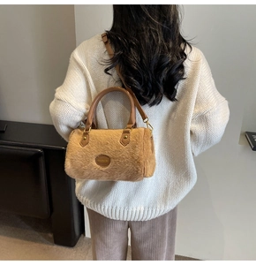 Sac cylindre marron en fausse fourrure pelucheuse porté avec un pull en tricot blanc chic