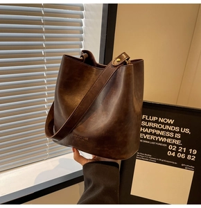 Detailed view of deep brown vintage bucket bag with leather texture and gold hardware accents