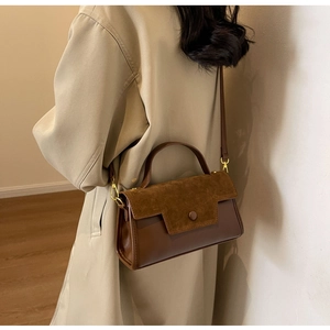 Brown leather and suede shoulder bag shown on model for stylish size perspective