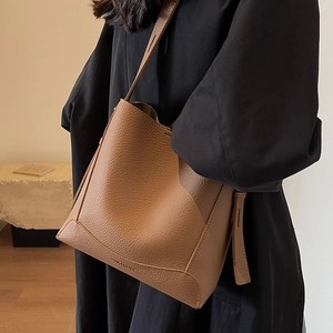Minimalist brown lychee leather bucket bag for women with elegant shoulder strap