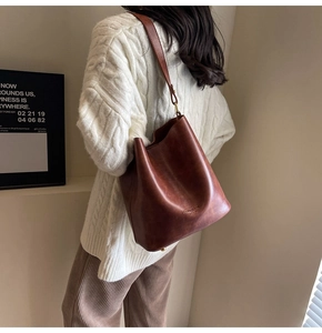 Brown leather bucket bag styled with an autumn knit sweater for casual daily commuting